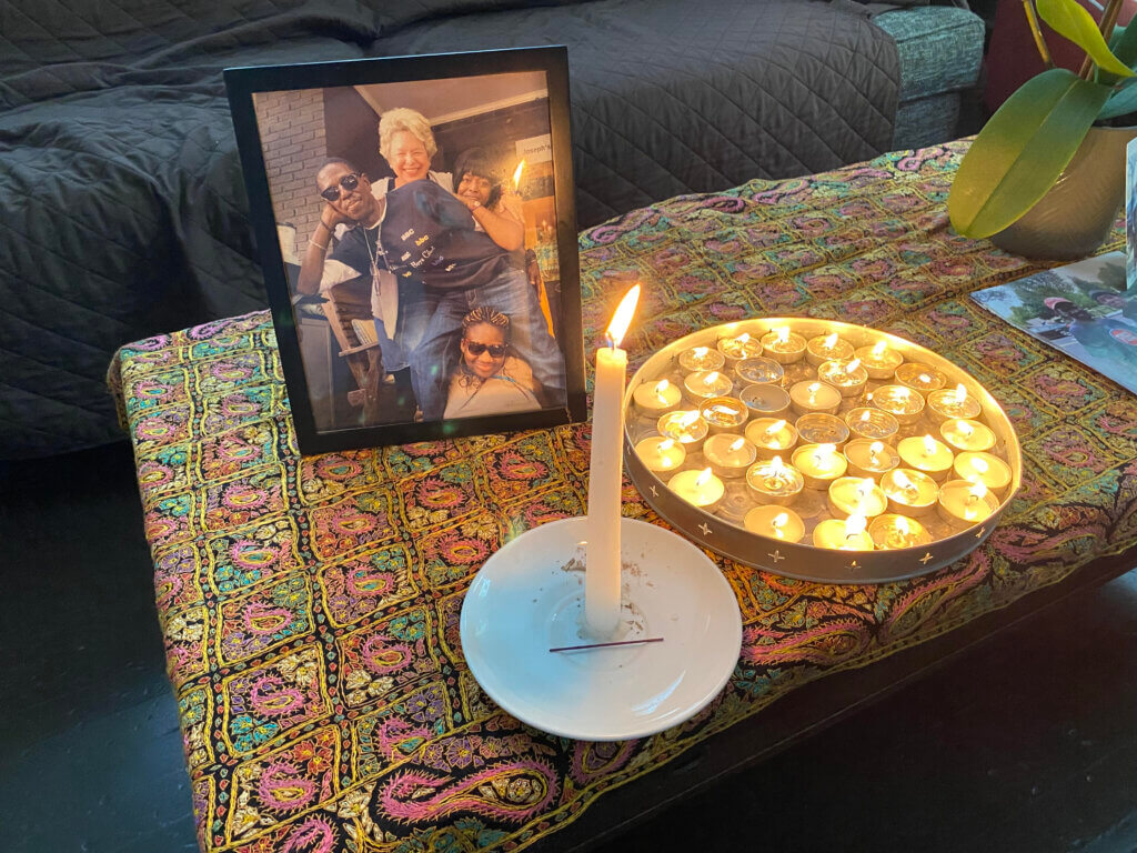A table with a picture and candles on it.
